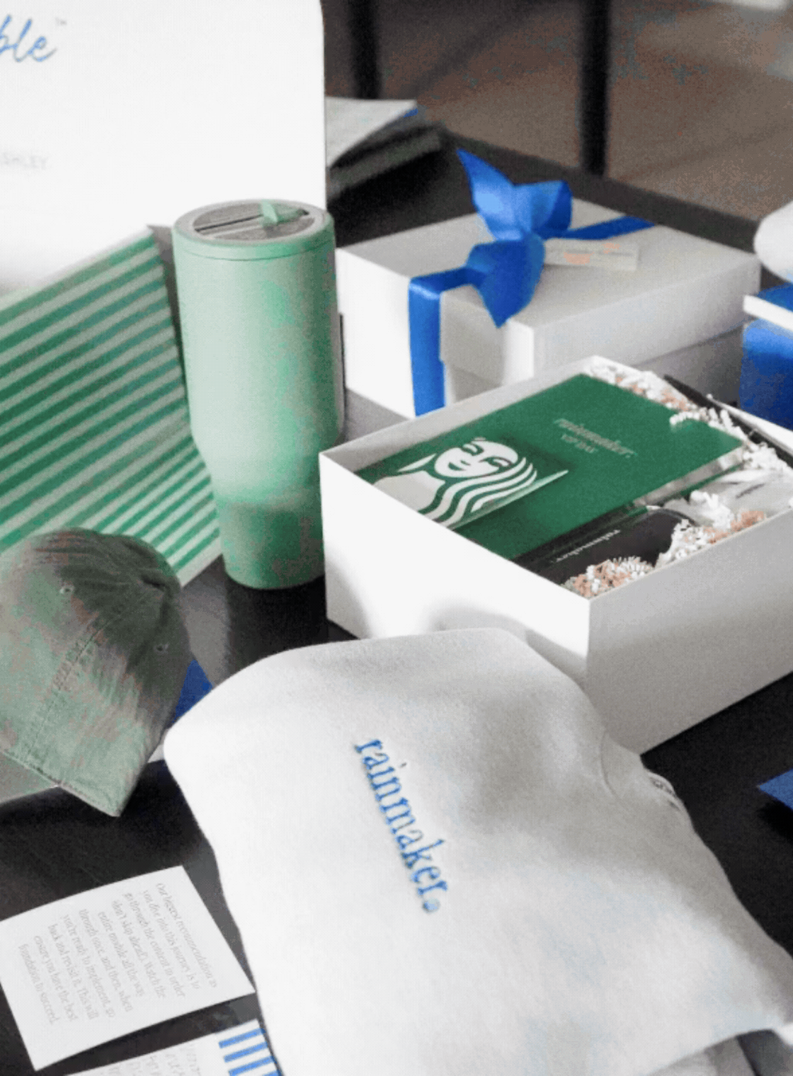 Close-up of branded onboarding gifts styled in a blue mailer box