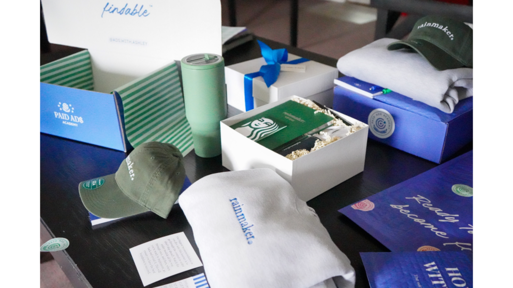 A curated spread of branded onboarding gifts arranged on a dark table