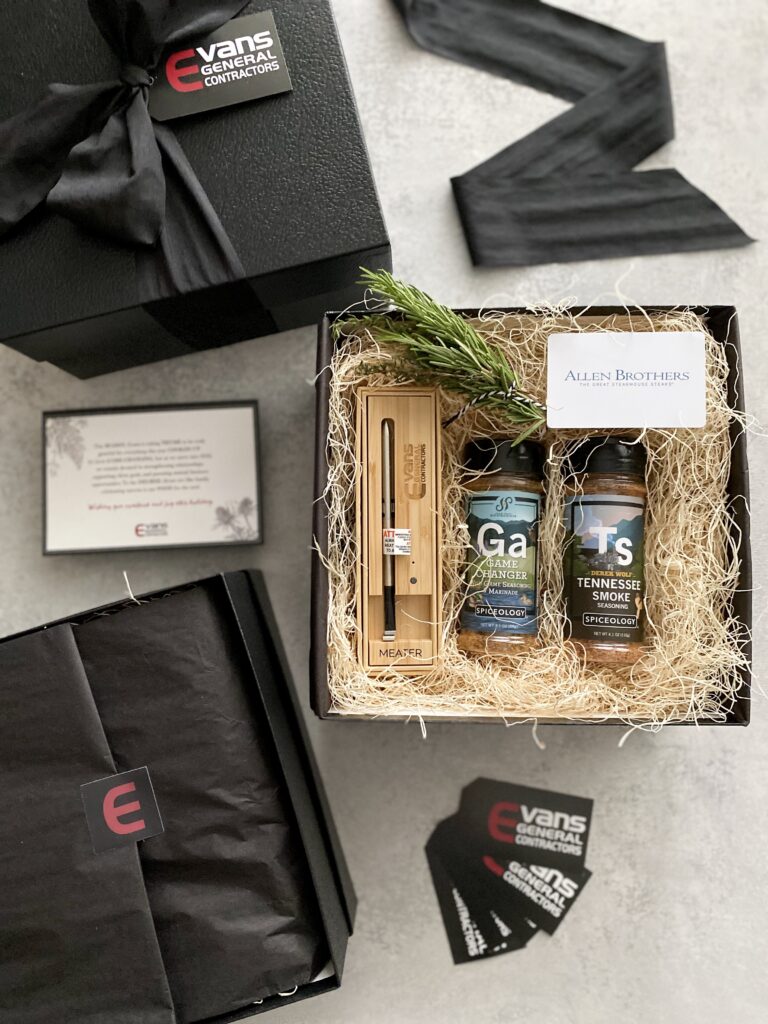Corporate Christmas gift box for grillers with meat thermometer, spice seasonings, rosemary sprig, and steakhouse gift card