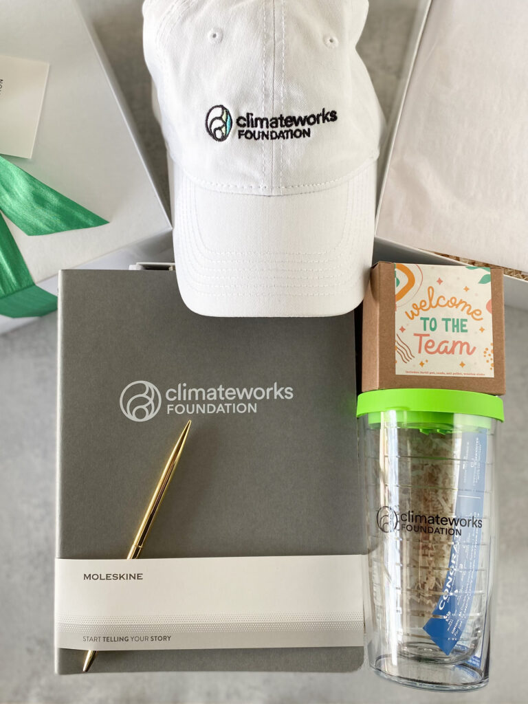 New hire welcome kit with branded notebook, pen, cap, and a plantable "Welcome to the Team" seed kit