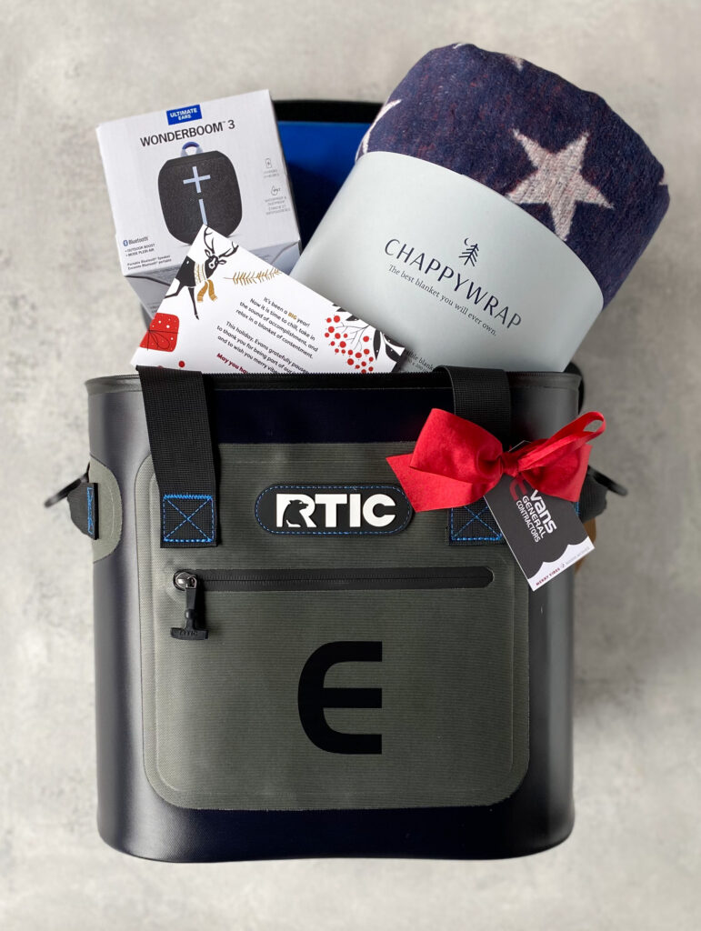 Corporate Christmas gift with branded cooler bag, star-print blanket, portable Bluetooth speaker, and red velvet bow